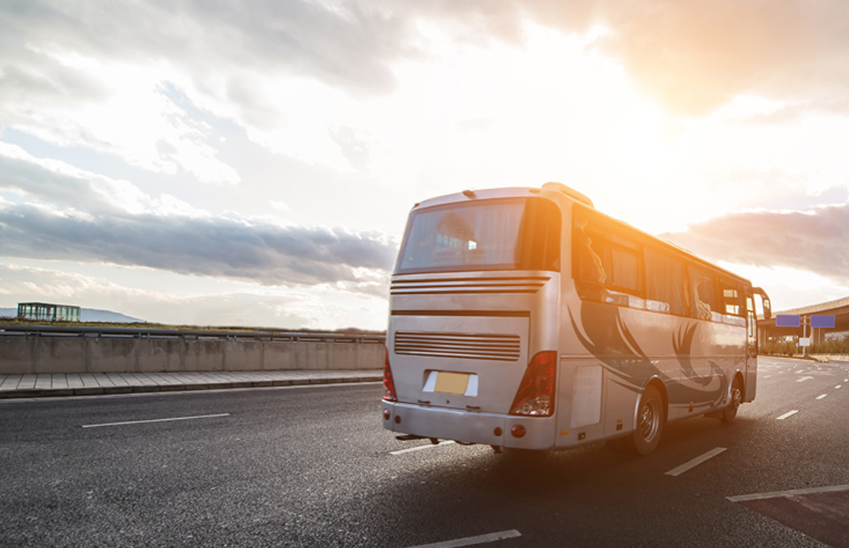 Bus auf einer Straße im Abendlicht