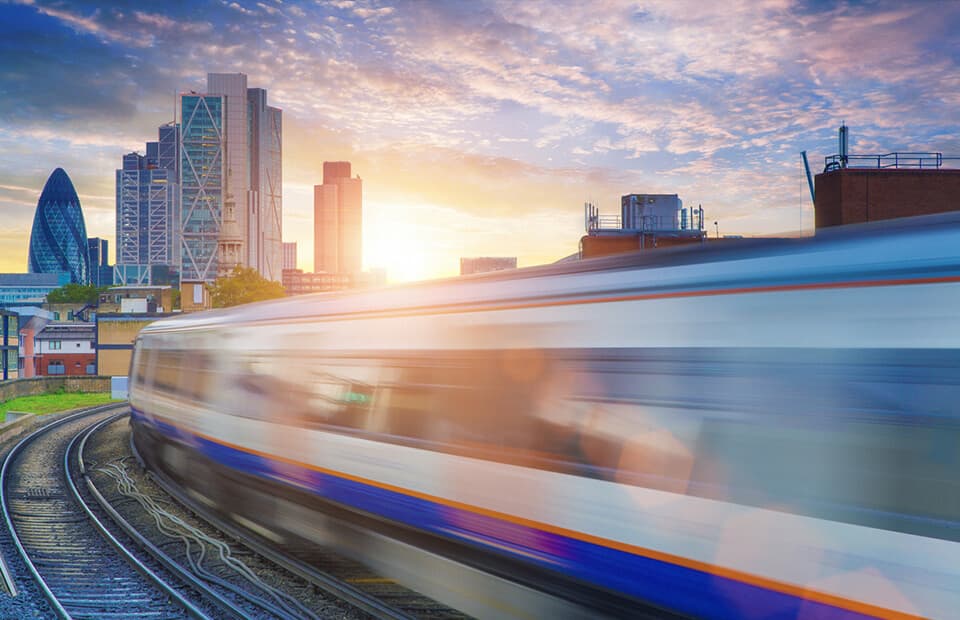 Fast moving commuter train driving into London City