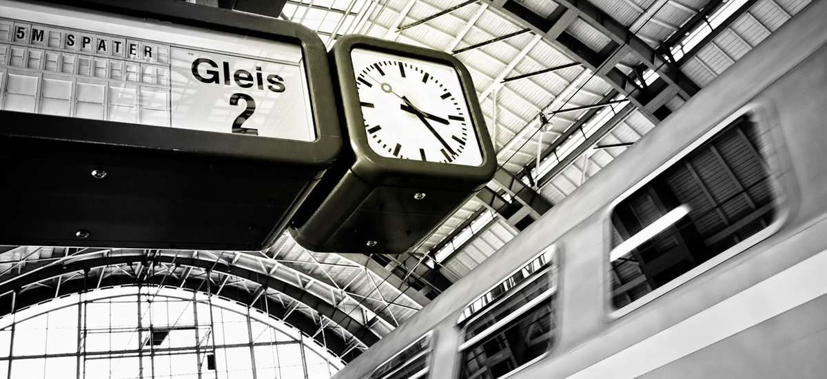 Train arrives at the station with a 5 minute delay - visible on the display panel next to the clock